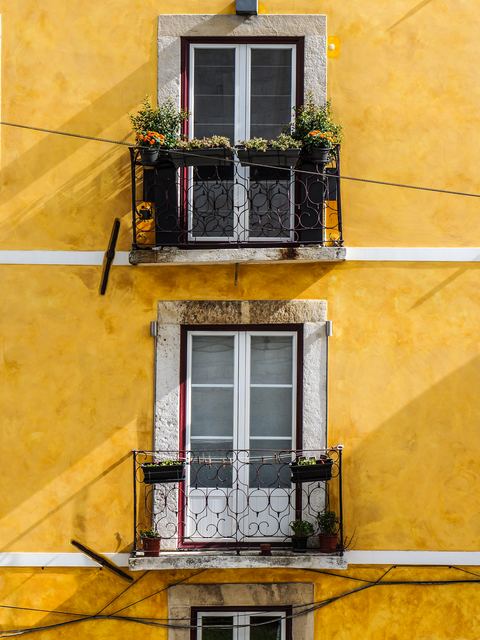 Yellow building front with small iron balconies