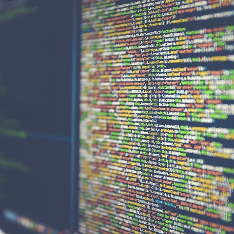 Close view of colorful lines of code on a dark monitor