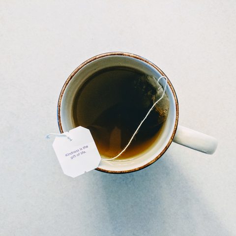 A cup of tea with the tag hanging over the rim, seen from above