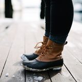 Winter boots with leather uppers on a wooden pier