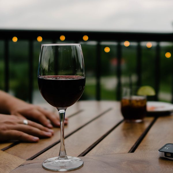 A glass of red wine on a wooden table on a terrace