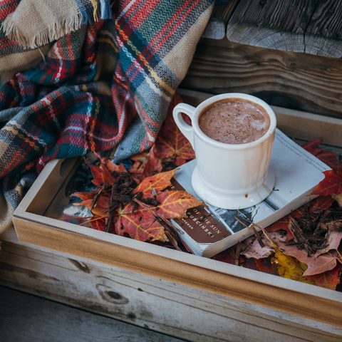 Mug of hot chocolate with cream on a wooden table