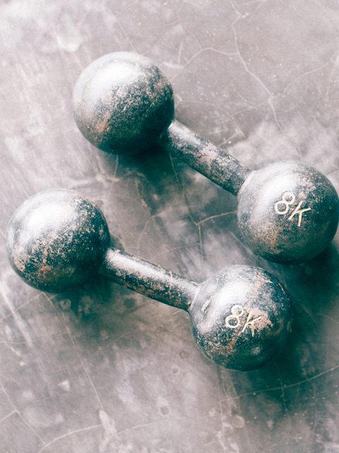 A pair of iron dumbbells on a grey concrete floor